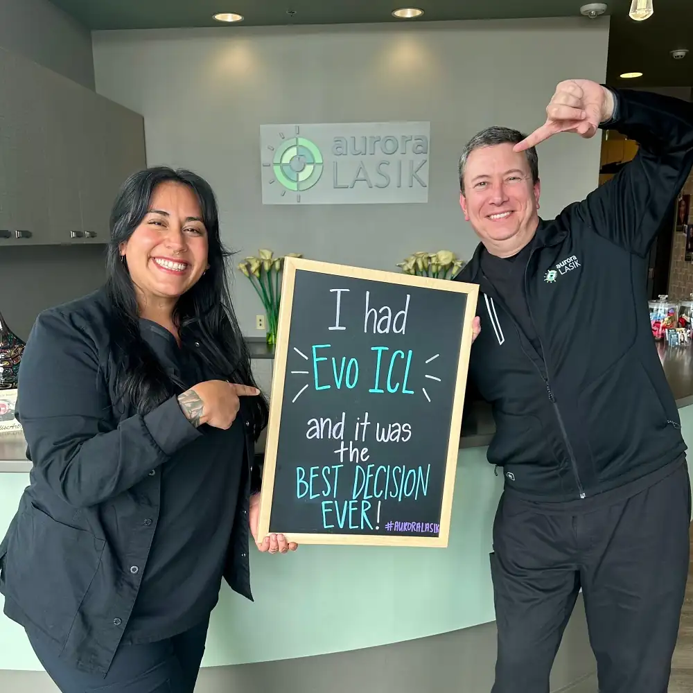 evo-icl-patient-aurora-lasik Dr. Munson and Audrey posing with a positive sign in the office lobby